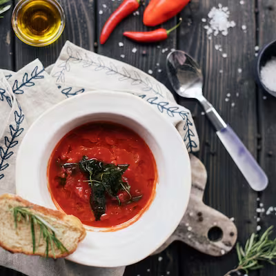 Red soup cooked with smoked paprika in white ceramic bowl